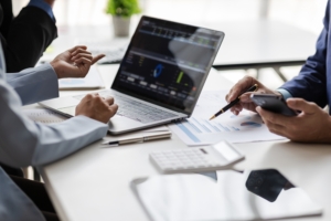 Two financial professionals from the S.A. Associates team delivering CFO services Kitchener reviewing financial reports and performance charts on a laptop during a client meeting.