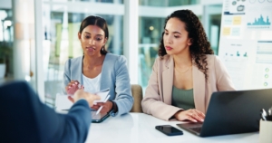 Business leaders reviewing financial reports and charts during a cash flow projection discussion to improve financial planning and forecasting.