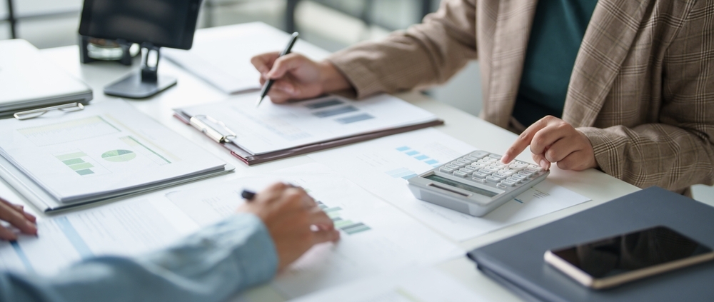 Business leaders reviewing financial reports while deciding whether to recruit a CFO in Toronto or use fractional CFO services.