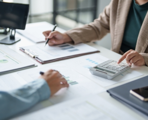 Business leaders reviewing financial reports while deciding whether to recruit a CFO in Toronto or use fractional CFO services.