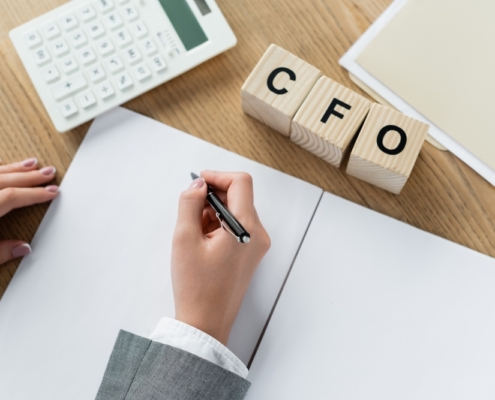 Business owner wondering when is it time to hire a CFO while reviewing financial reports at a desk in Guelph Ontario